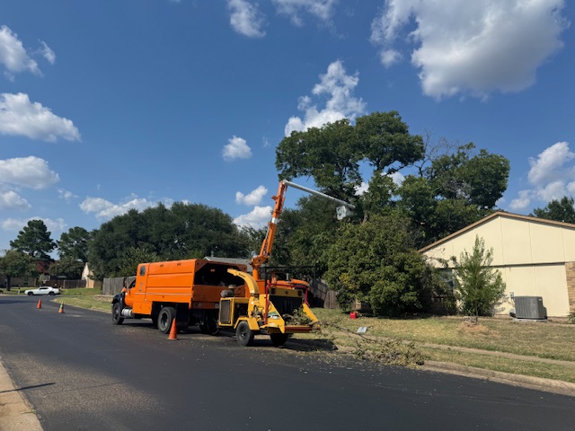 Professional bucket truck and chipper operation with safety cones